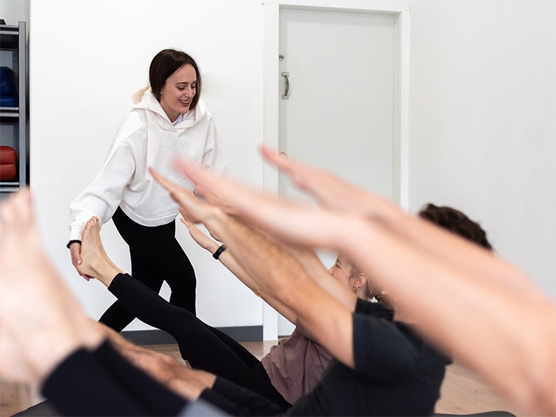 new 4th image group of people doing mat pilates classs with instructor